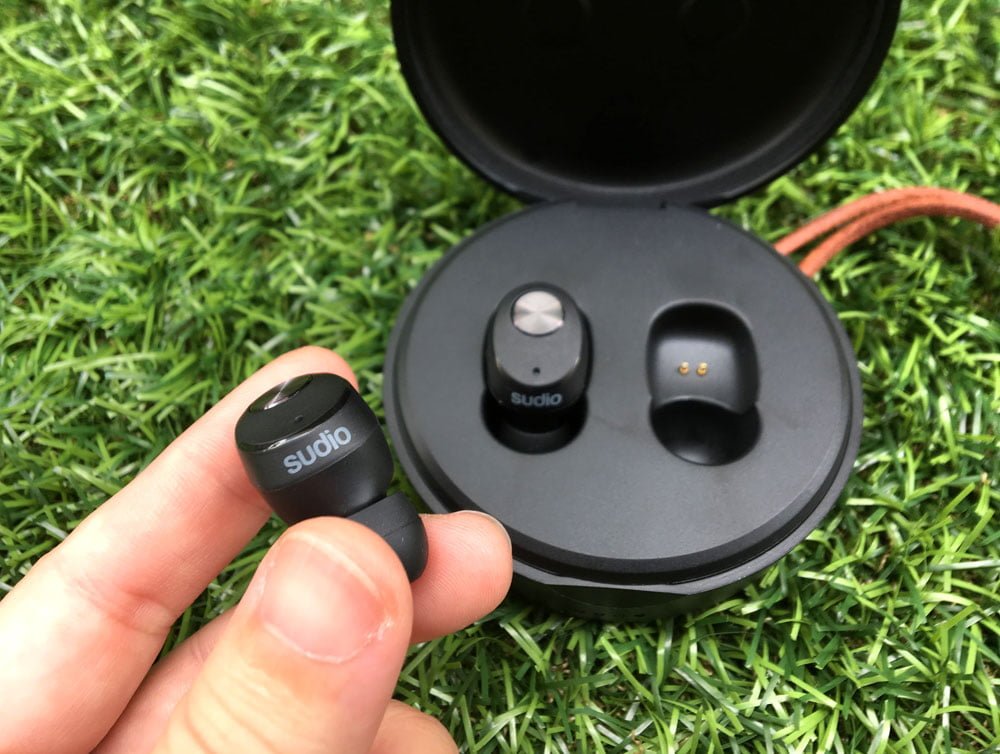 comparing the size of the earbuds and case with my hand