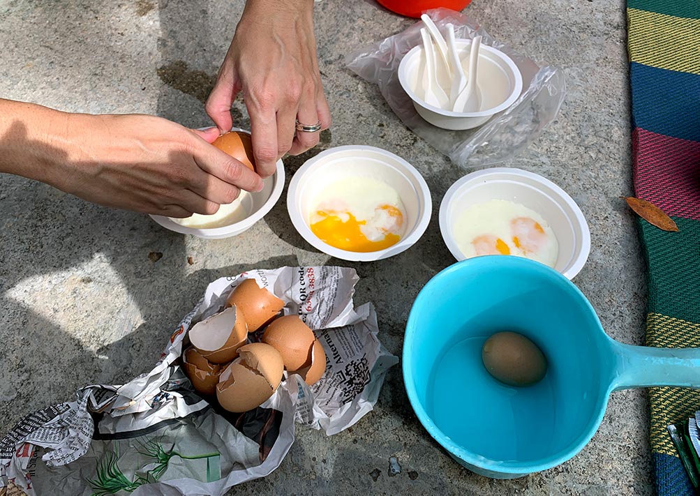 Perfectly runny half boiled eggs cracked into bowls, yum