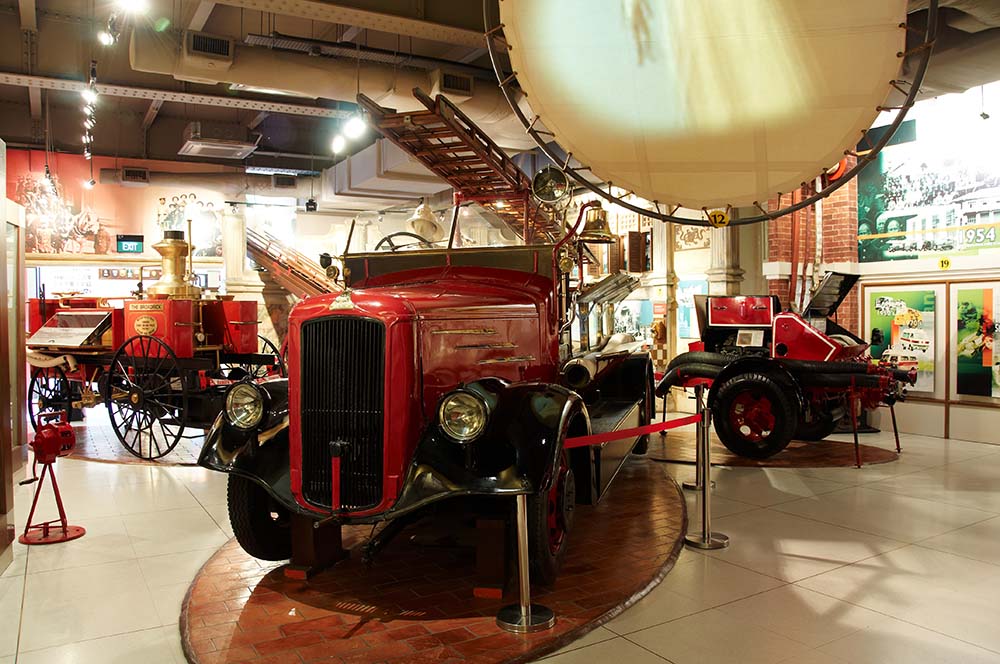 Red vintage fire trucks in an indoor gallery